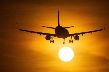 Güneşin arka planda güzel kırmızı bulutlar ile yakın air uçak silueti