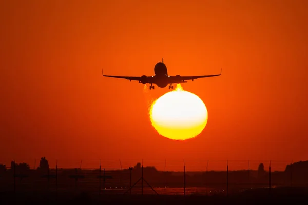 Sziluettjét egy légi plane felett a nap szép piros felhő — Stock Fotó