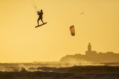 Asian kitesurfers Essaouira, Fas gün batımında büyük dalgalar zevk. Arka planda güzel manzara