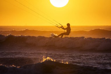 Asian kitesurfers Essaouira, Fas gün batımında büyük dalgalar zevk. Arka planda güzel manzara