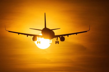 Güneşin arka planda güzel kırmızı bulutlar ile yakın air uçak silueti