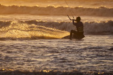 Asian kitesurfers Essaouira, Fas gün batımında büyük dalgalar zevk. Arka planda güzel manzara