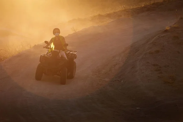 バック グラウンドで粉塵の多いカッパドキアの谷の日没の Atv を運転を楽しむ人々 — ストック写真