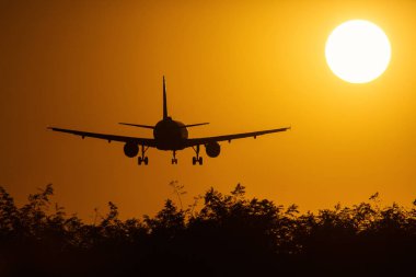 Bir hava uçağı ile arka planda güzel kırmızı bulutlar güneşin ele silüeti