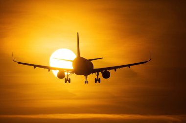 Bir hava uçağı ile arka planda güzel kırmızı bulutlar güneşin ele silüeti