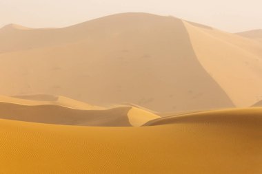 Sahara çöl güzel çizgiler ve renkler ile güneş doğarken. Merzouga, Fas
