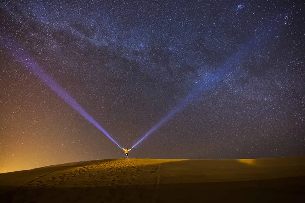 美しい天の川と満天の背景の星のデザートの途中で夜にランタンで遊んで男 — ストック写真