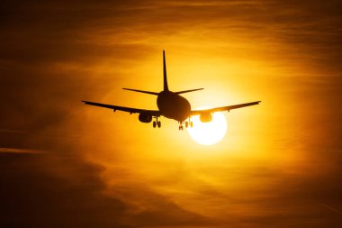 Bir hava uçağı ile arka planda güzel kırmızı bulutlar güneşin ele silüeti