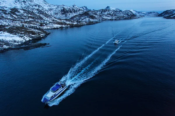 背景に雪でいっぱいの山々と日の出前に釣りに行く魚船 ノルウェーのロフテン島 — ストック写真