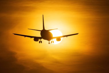 Bir hava uçağı ile arka planda güzel kırmızı bulutlar güneşin ele silüeti