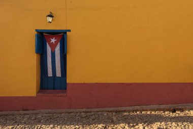 Pencerede Küba bayrağı Trinidad caddesinde güzel bir çerçeveyle