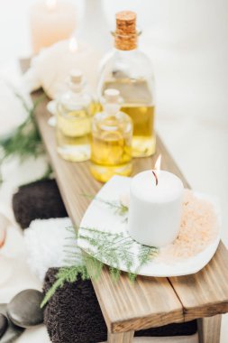 uçucu yağ, tuz ile spa tedavisi aksesuar düzenlemenin görünümü kadar kapatın ve beyaz arka plan üzerinde mum