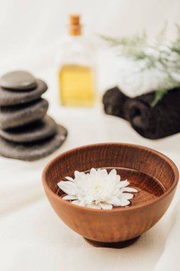 spa tedavisi aksesuar ve beyaz arka plan üzerinde ahşap kase kasımpatı çiçeği düzenlemenin seçici odak