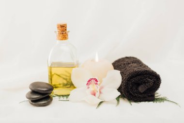 Beyaz arka plan üzerinde orkide çiçek yağı, havlu ile spa tedavisi aksesuar düzenlemenin görünümü kadar kapatın