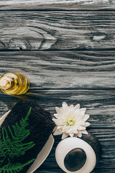 スパとフラットに置くし マッサージ治療提携木製卓上型のオイル タオル 小石や菊の花 — ストック写真