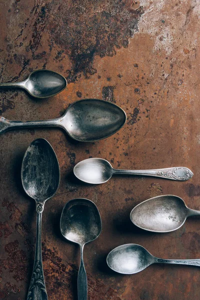 top view of silver spoons on grungy table