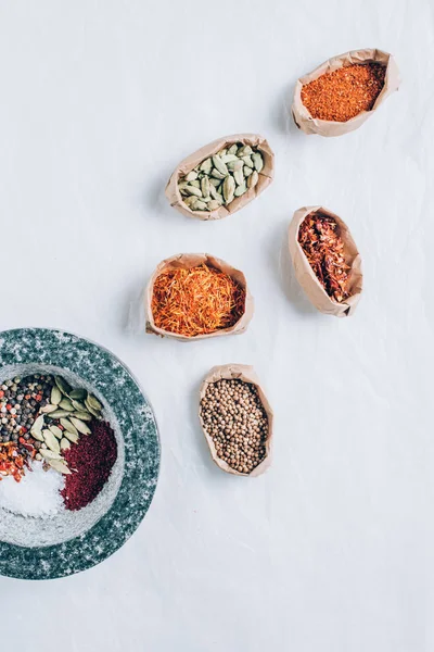 kağıt poşet ve harç içinde baharatlar üstten görünüm beyaz masada