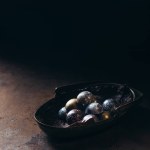 Haufen verschiedener Schokoladenbonbons in Metallkorb auf schwarzem Hintergrund Haufen verschiedener Schokoladenbonbons in Metallkorb auf schwarzem Hintergrund