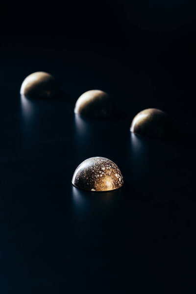 close up image of chocolate candies on black background 