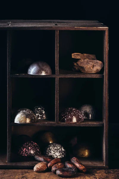 黒い背景に棚にナッツ チョコレートの部分やキャンディーのクローズ アップ ビュー — ストック写真
