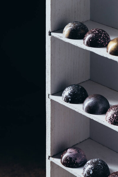 different chocolate candies placed in rows on shelves 