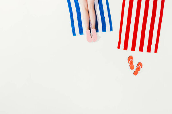 cropped shot of person resting on striped beach towel isolated on white