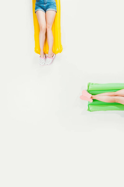 cropped shot of people lying on inflatable mattresses and relaxing isolated on white