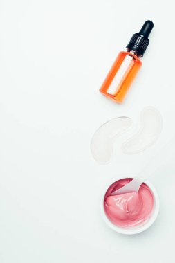 Boru, göz yamalar, kaşık ve üzerinde beyaz izole kap içinde pembe maske ile Kozmetik şişe üstten görünüm 
