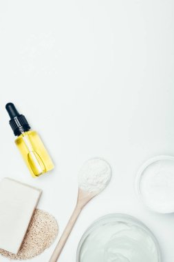 düz lay beyaz yüzey üzerinde izole boru ve kil tozu ile Kozmetik şişe sabun, sünger, kaşık, konteynırlar, kil maskeleri ile 