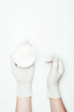Lateks eldiven konteyner ile kil maskesi ve üzerinde beyaz izole kaşık tutan kadının kırpılmış görüntü