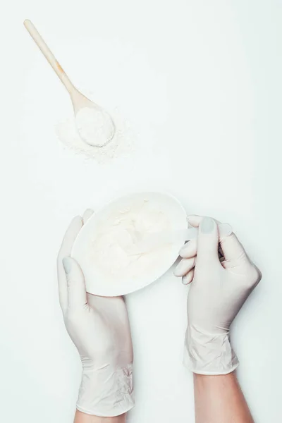 スプーンと粘土の粉が付いている表面に粘土マスク プレート付きラテックス手袋の女性のクロップ撮影 — ストック写真