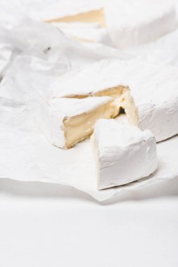 buruşuk Kağıt ve beyaz yüzey Brie peyniri dilimlenmiş