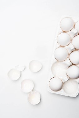 Beyaz yüzey üzerinde çiğ tavuk yumurta karton üstten görünüm