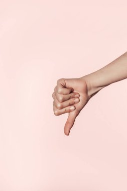 kadının başparmak aşağı pembe arka plan izole jest yapması kırpılmış atış 