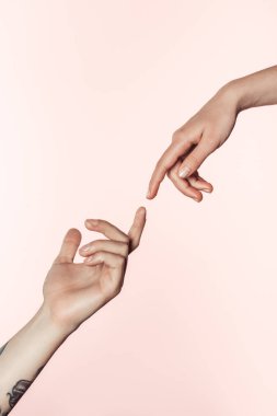 cropped shot of tattooed man and woman approaching to each other by fingers isolated on pink background clipart