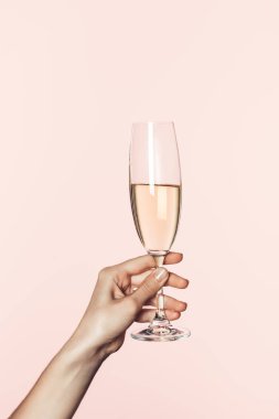 partial view of woman holding champagne glass isolated on pink background  clipart