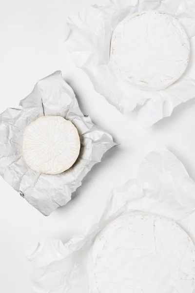 Top View Organic Brie Cheese Heads Crumpled Paper White Surface — Free Stock Photo