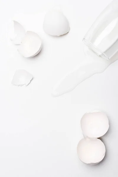 Bovenaanzicht Van Gebroken Kip Eierschalen Met Gemorste Melk Witte Ondergrond — Stockfoto