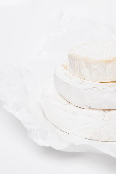 Pilha Deliciosas Cabeças Queijo Brie Papel Amassado Superfície Branca — Fotografia de Stock Grátis