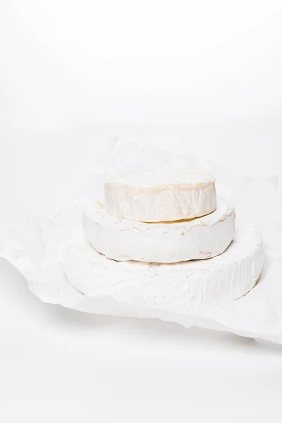 Pila Sabrosas Cabezas Queso Brie Sobre Papel Arrugado Superficie Blanca — Foto de stock gratis