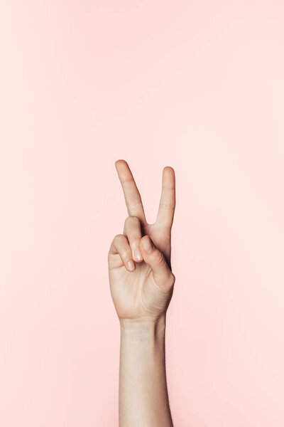 cropped shot of woman doing peace sign isolated on pink background 