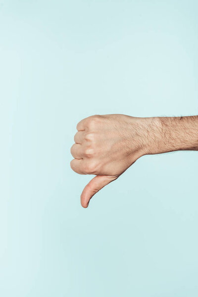 cropped shot of man doing thumb down gesture isolated on blue background 