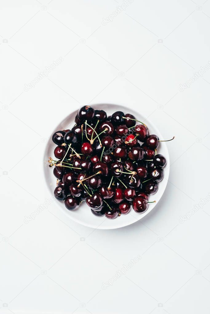 top view of fresh ripe sweet cherries in bowl on white 