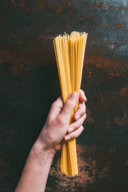 pişmemiş spagetti rustik metal masa üzerinde tutan adamın resim kırpılmış 