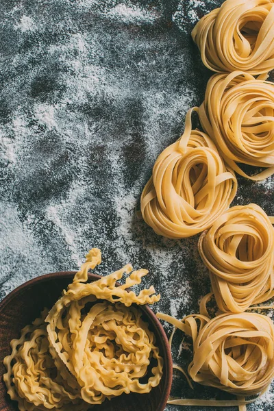 Bovenaanzicht Van Ruwe Pasta Kom Tafel Gedekt Door Bloem — Stockfoto