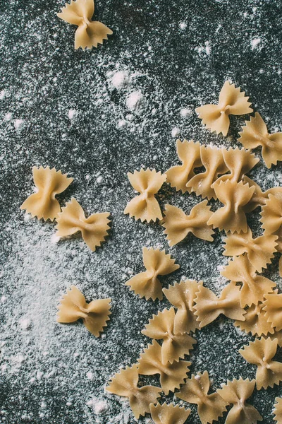 Vista Superior Macarrão Farfalle Cru Mesa Coberta Farinha — Fotografia de Stock