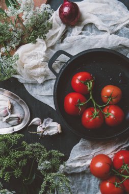 tavada domates maydanoz çiçek ve sarımsak ile gazlı bez üzerinde yukarıdan 