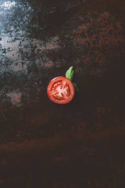 paslı arka plan üzerinde kırmızı ripe domates fesleğen ile yarısının üstten görünüm bırakır