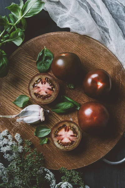 黑王子西红柿 罗勒叶和大蒜在切板上的顶部的看法与纱布 — 图库照片