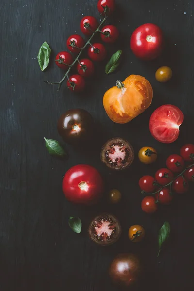 黑王子西红柿和樱桃西红柿的顶部视图在黑色木质背景罗勒叶子 — 免费的图库照片